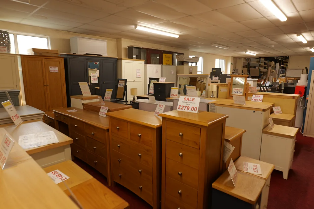 Wood-finish and painted chests, bedside cabinets and wardrobes in the showroom