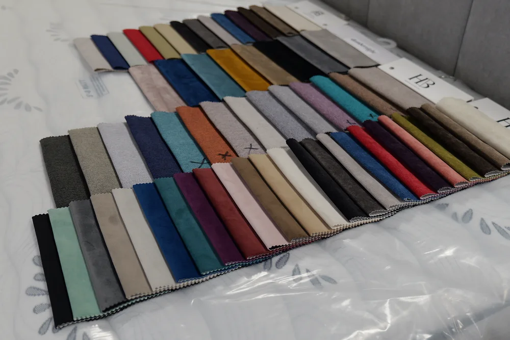 Fabric sample books laid out across a showroom bed
